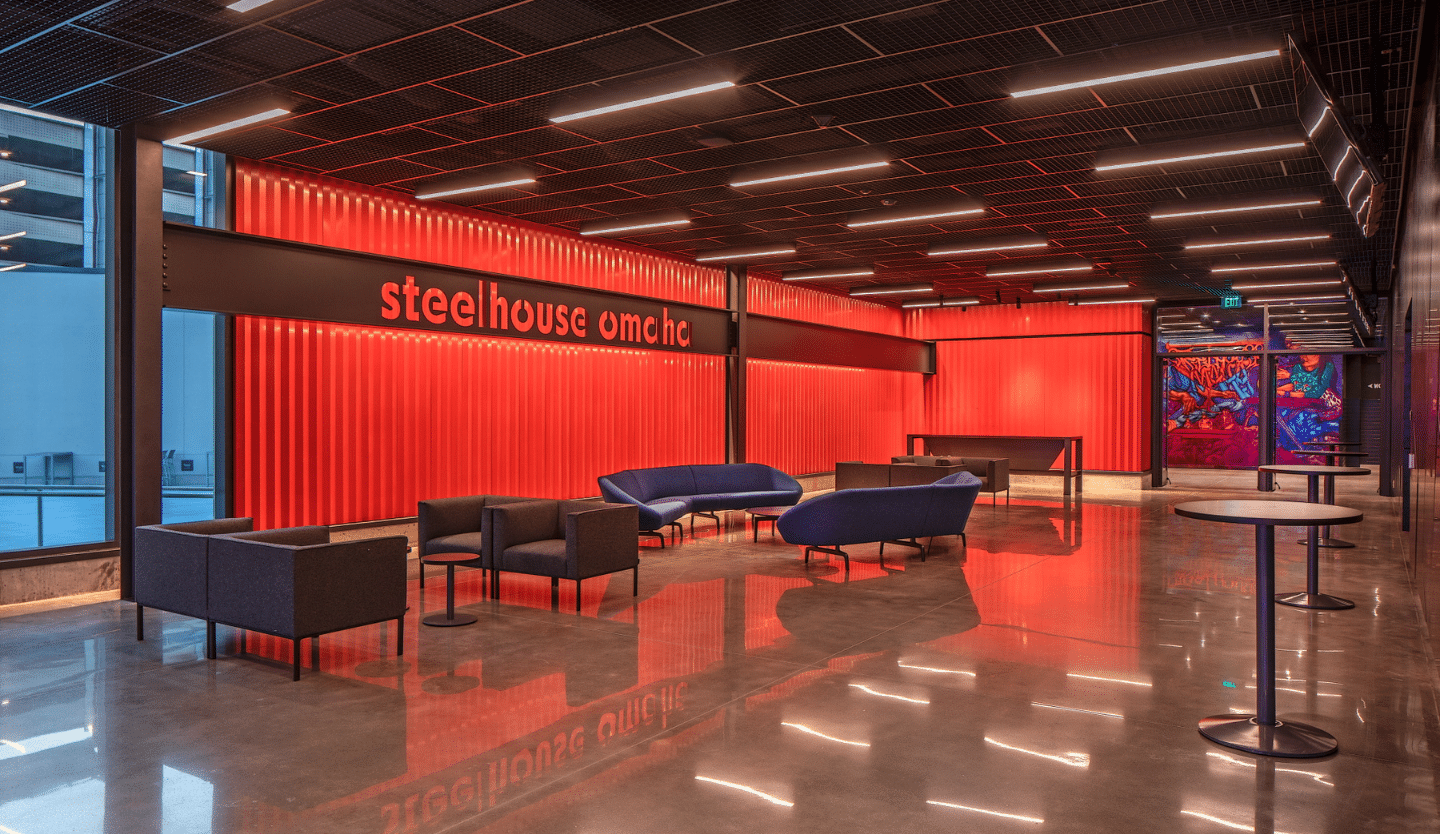 venue main lobby with furniture, red wall and steel beams with venue name